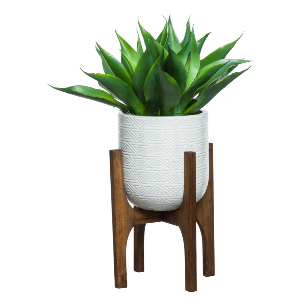 Faux agave plant in textured white ceramic pot on wooden stand, modern home decor