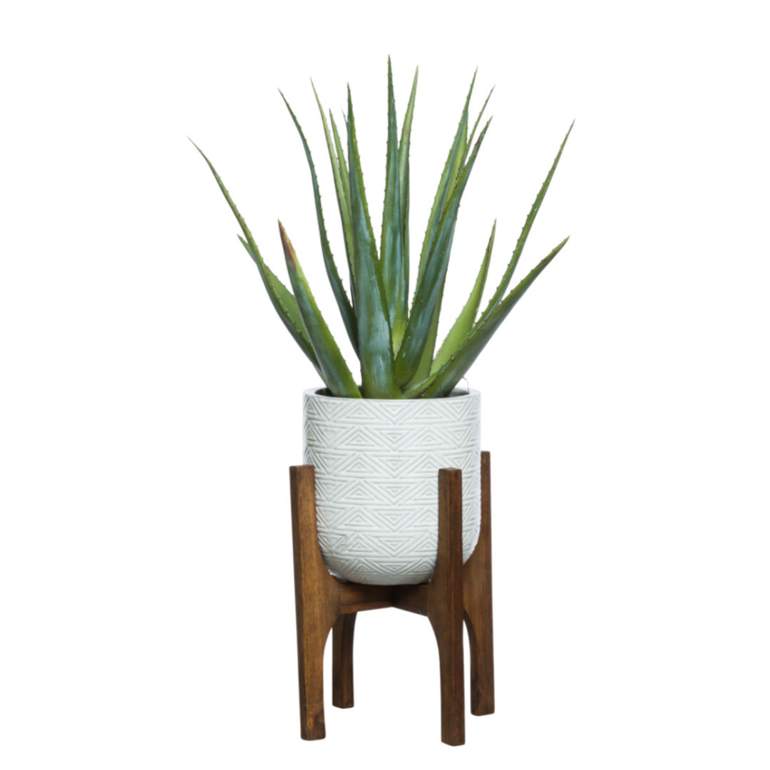 Artificial aloe plant in textured white pot on mid-century wooden stand