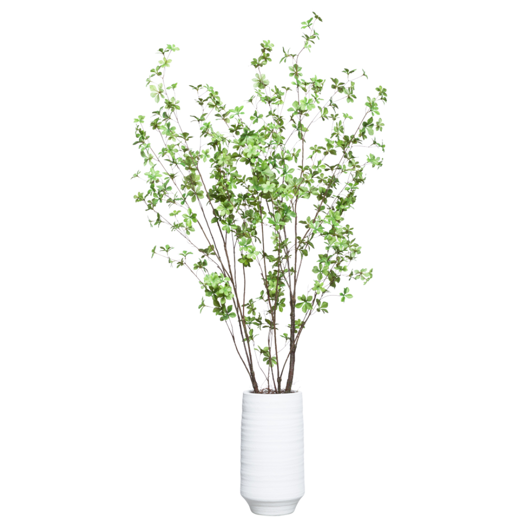Realistic artificial green branch arrangement in a white ceramic vase