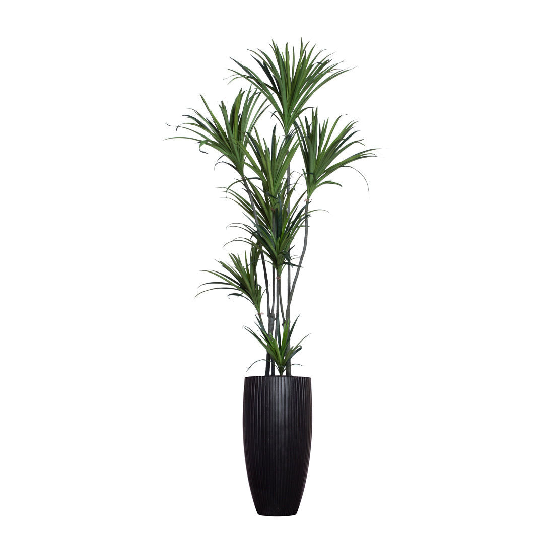 Artificial dracaena plant with slender green leaves in a tall black ribbed planter
