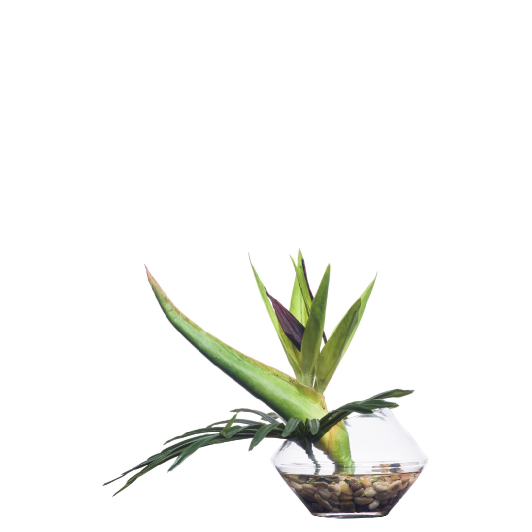 Artificial bird of paradise plant in a glass vase with pebbles, modern tabletop decor