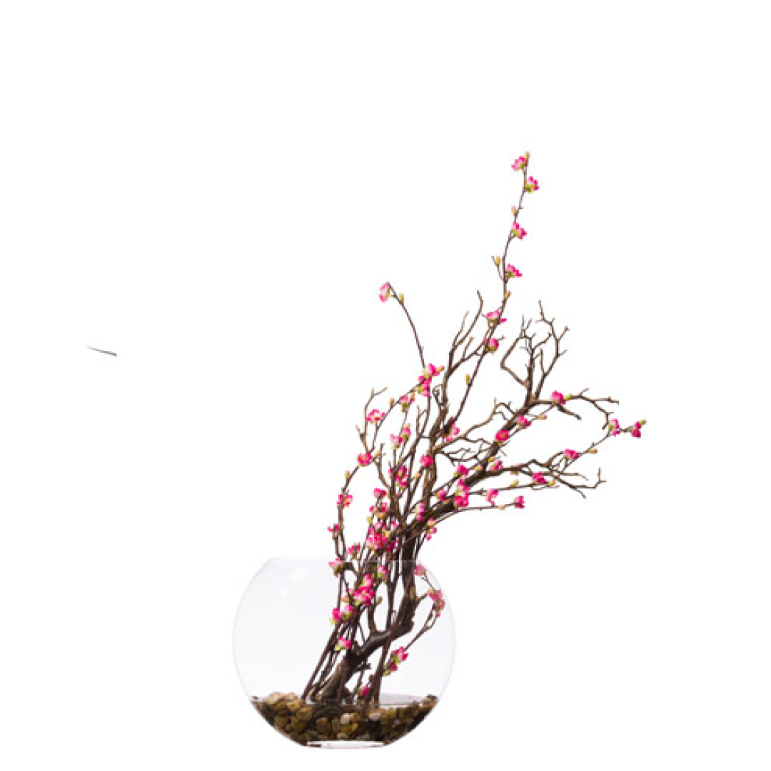 Artificial cherry blossom manzanita branches in a clear round glass vase with stones