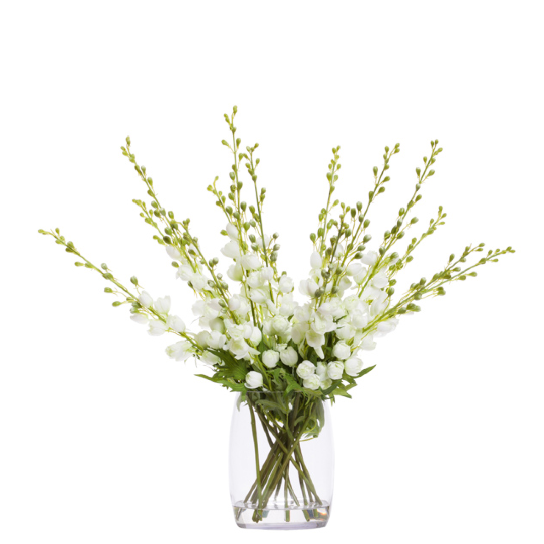 White artificial delphinium floral arrangement in a clear glass vase, modern decor