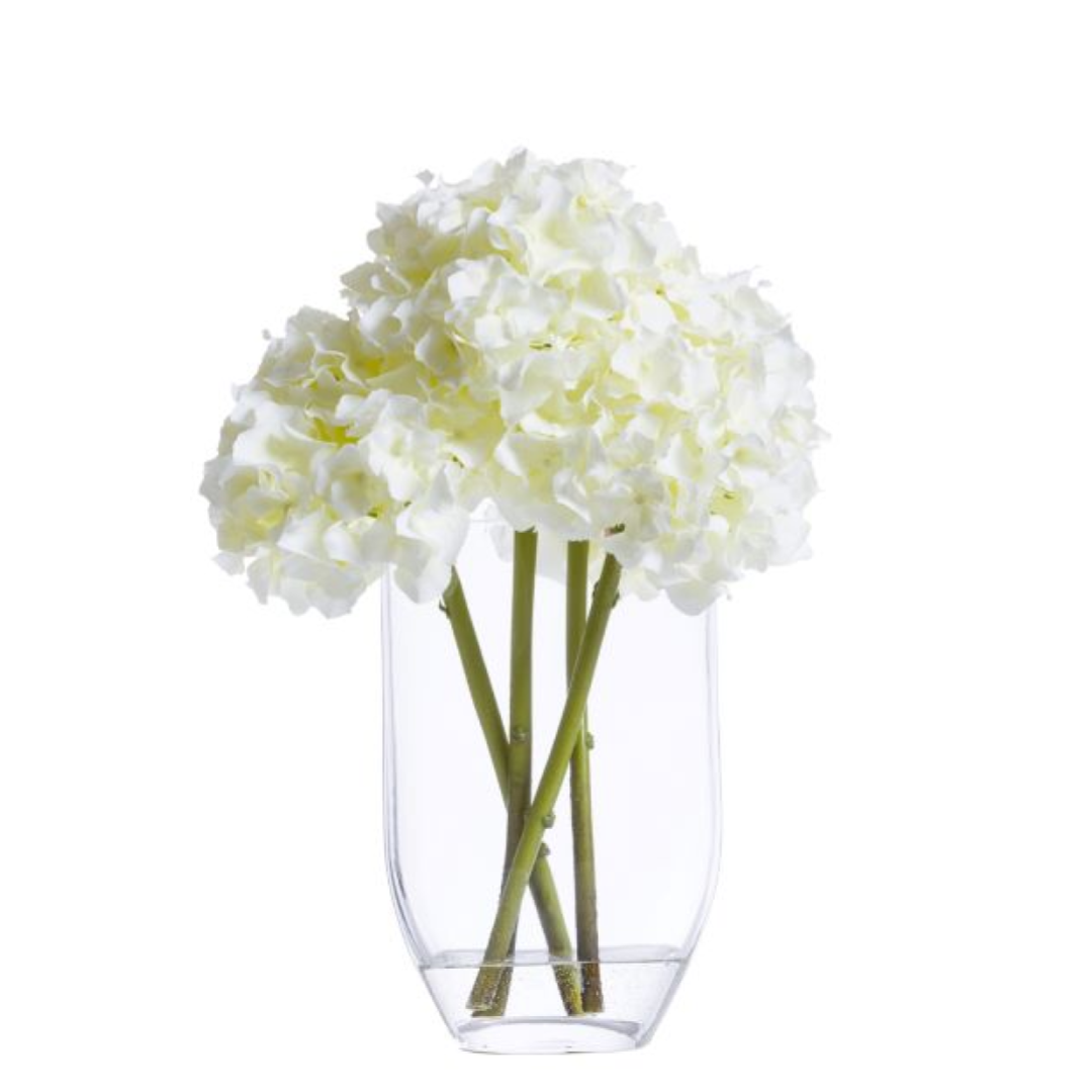 White hydrangea artificial flowers in a clear glass vase, modern home decor arrangement.