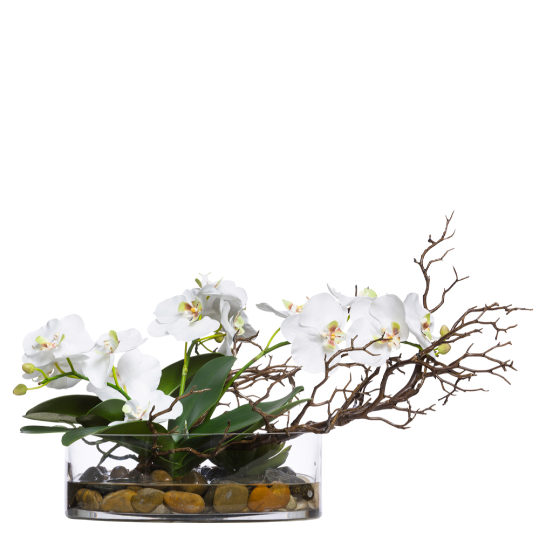 Artificial white orchid arrangement with manzanita branches and river stones in a clear vase