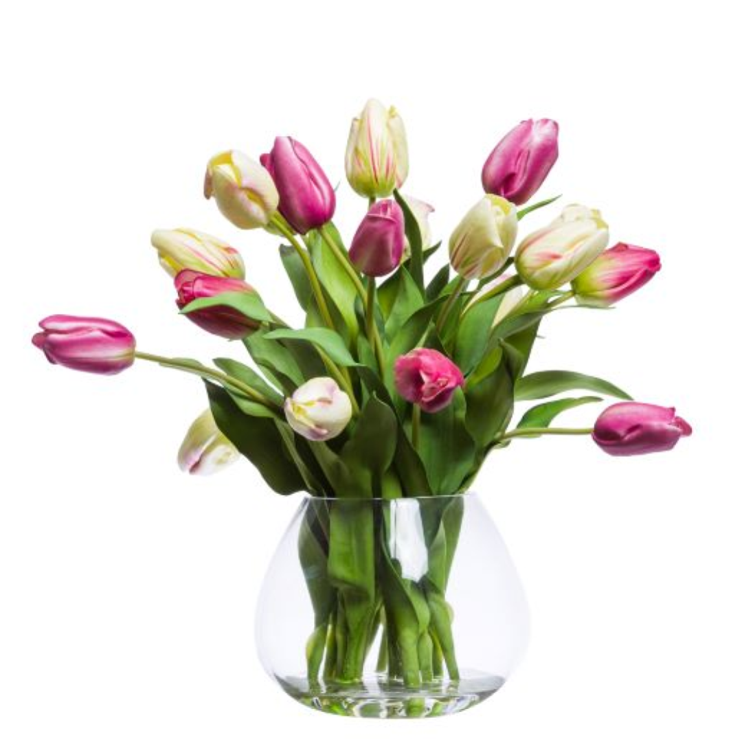 Pink and white artificial tulip bouquet in a clear glass vase on white background
