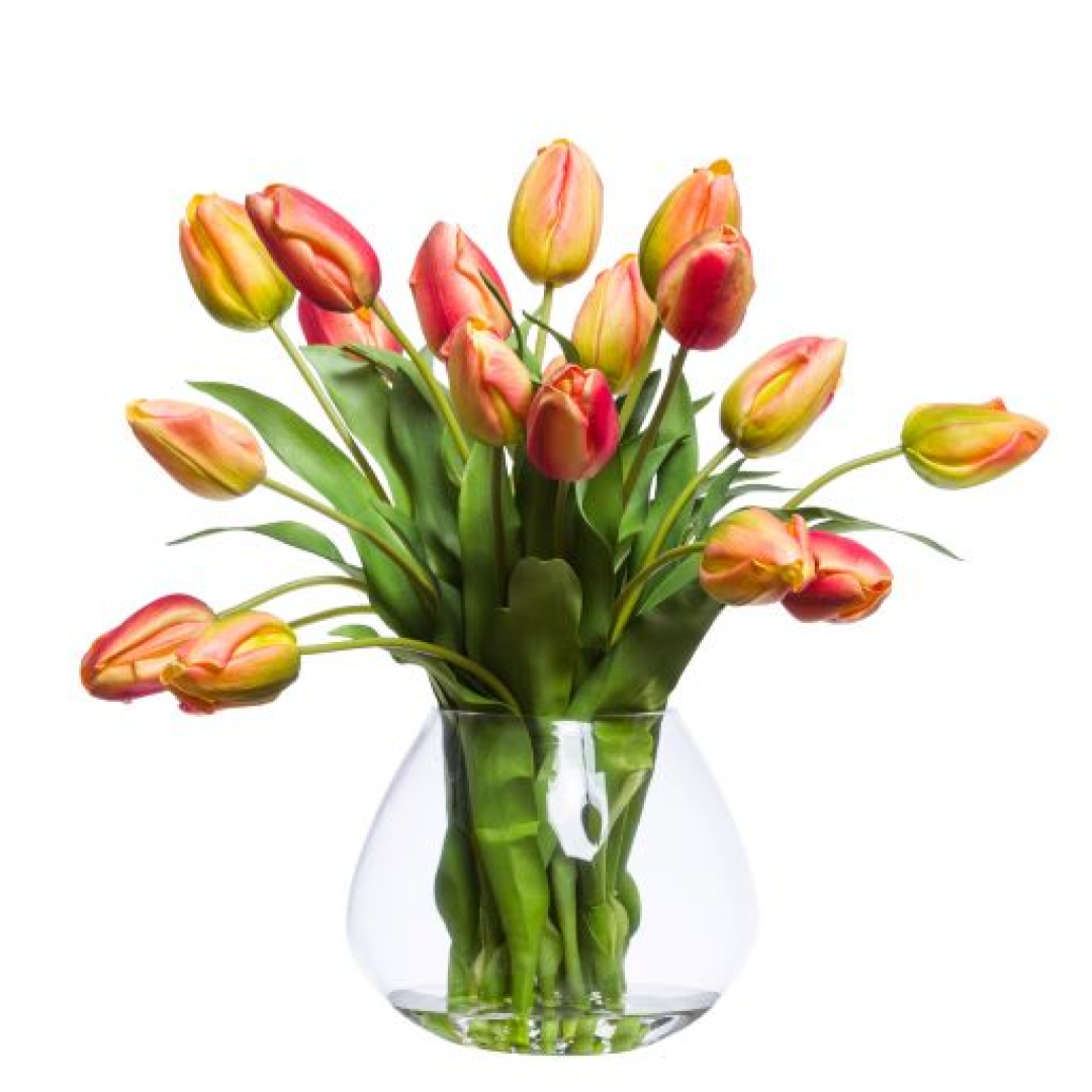 Realistic artificial orange-yellow tulips arranged in a clear glass vase on white background