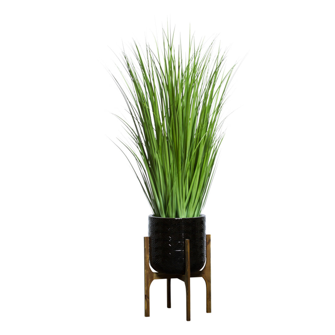 Artificial green wild grass in textured black pot on wooden stand, modern decor