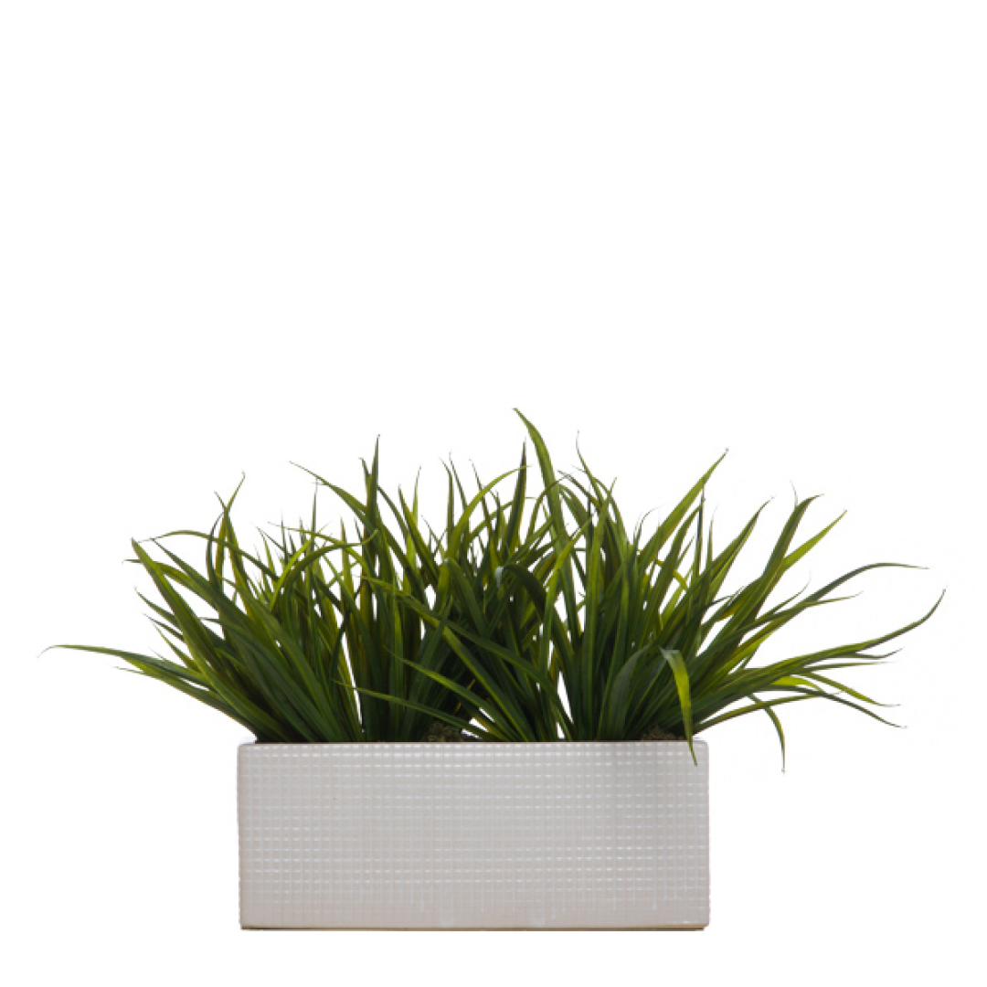 Artificial grass plant arrangement in a textured white rectangular planter