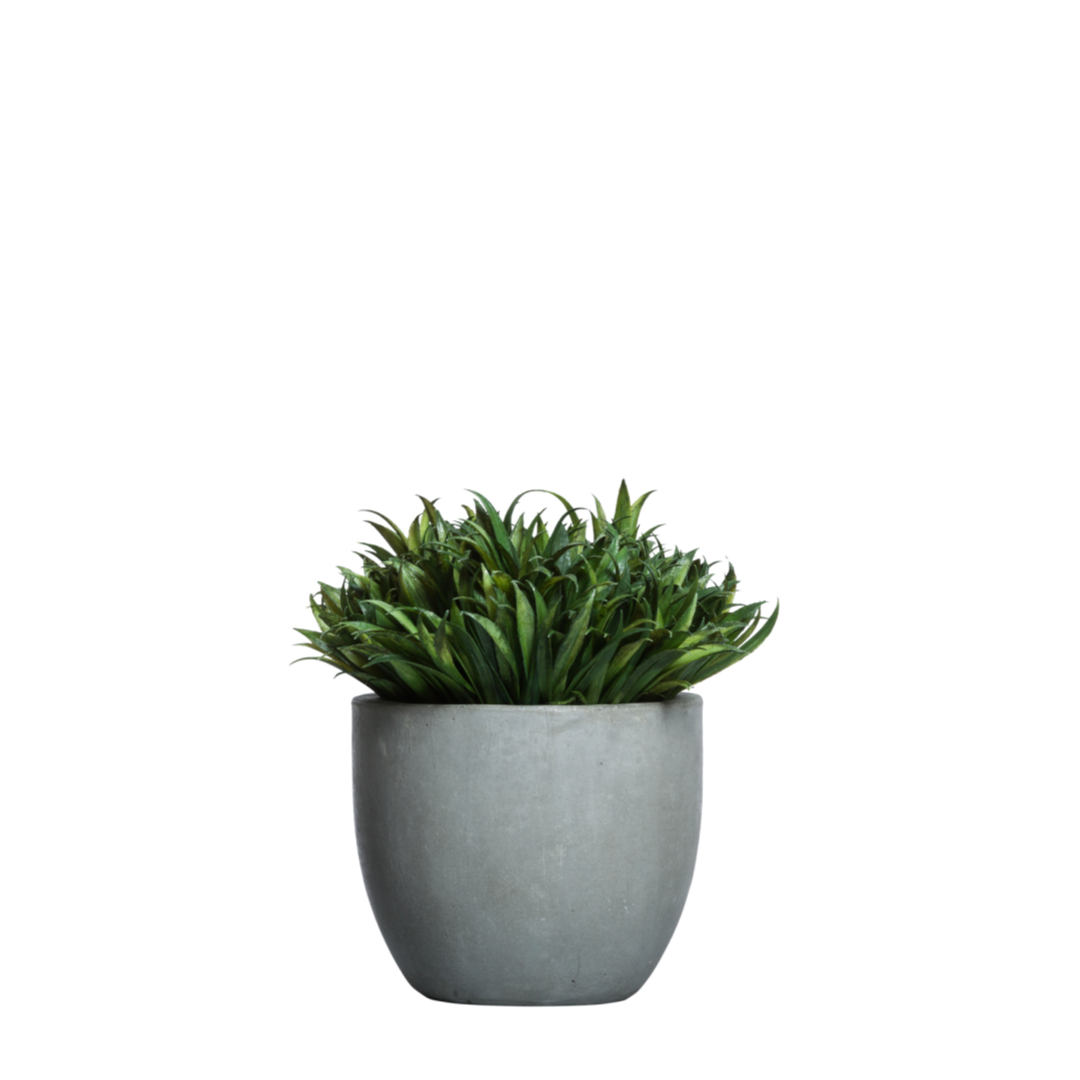 Lifelike artificial grass plant in a modern gray ceramic pot on white background