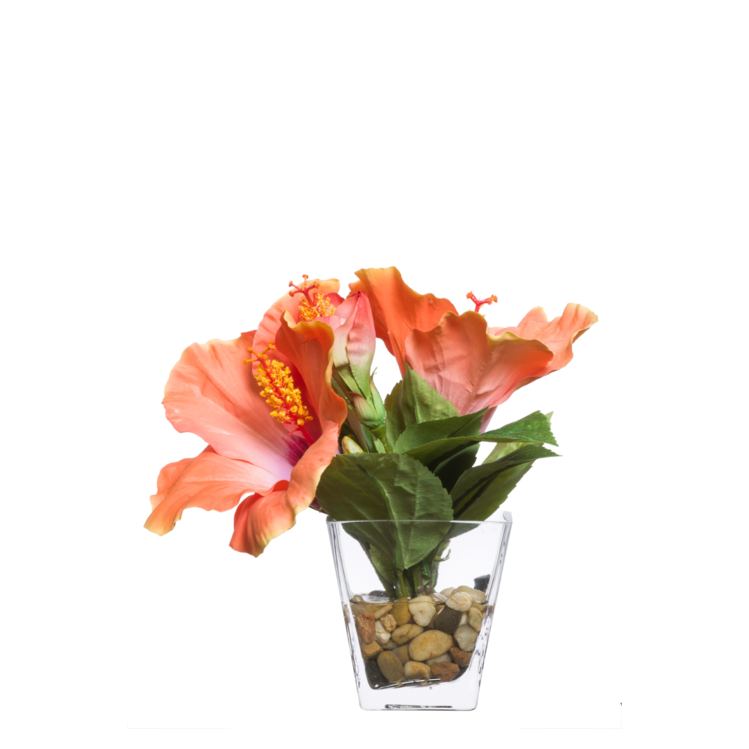 Artificial hibiscus flowers in glass vase with decorative stones, realistic silk arrangement