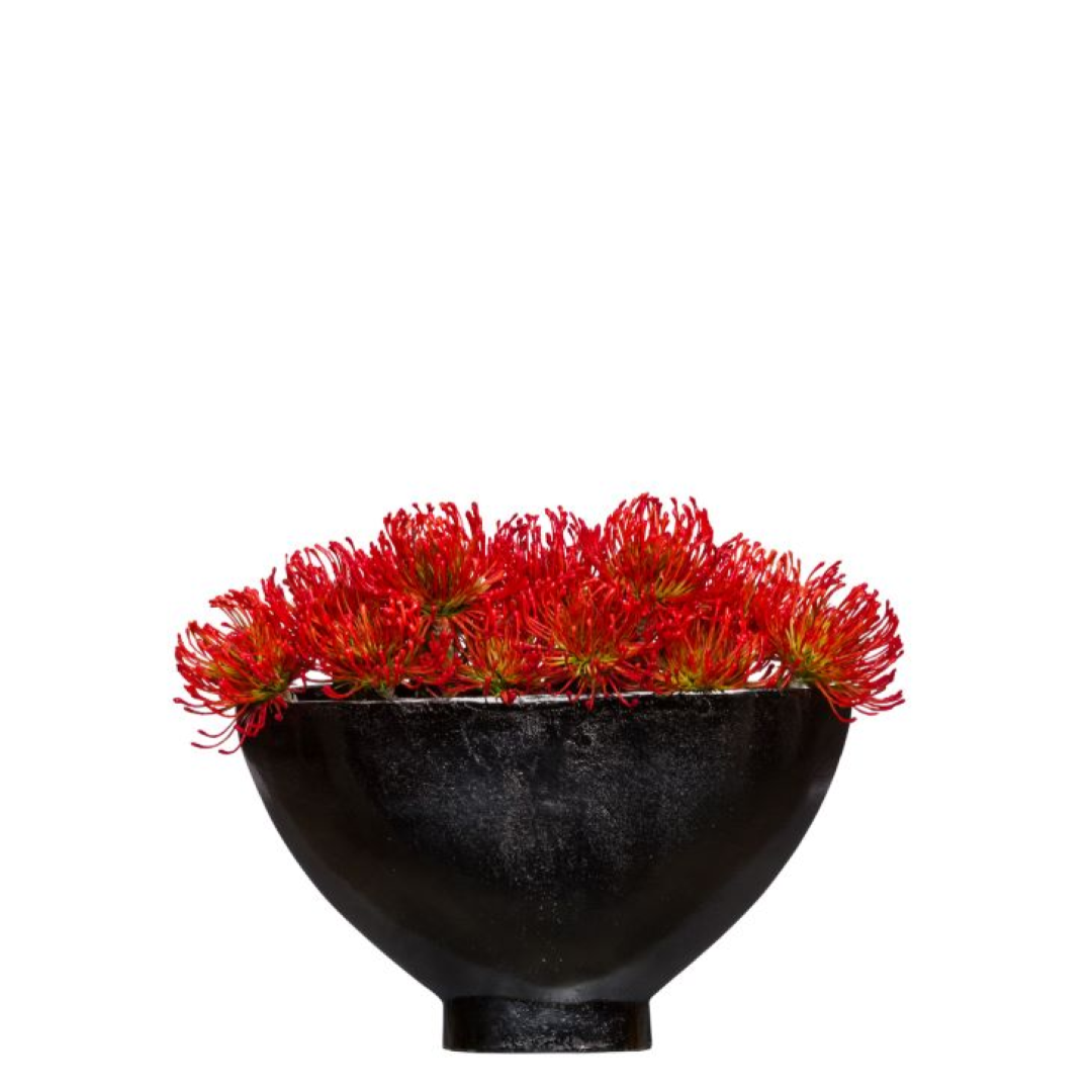 Vivid red artificial flowers arranged in a modern black bowl centerpiece