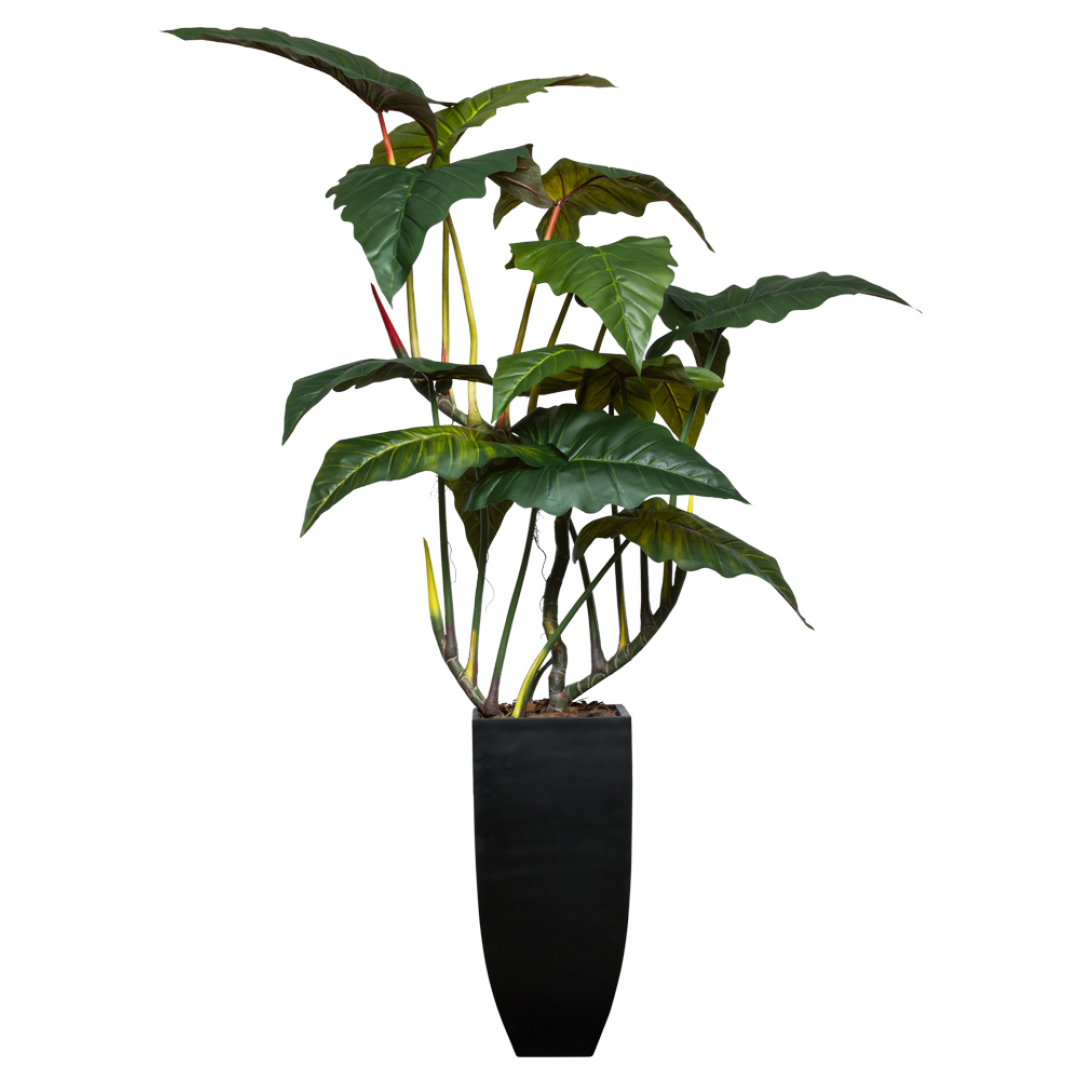 Artificial philodendron plant with broad green leaves in a tall black modern planter