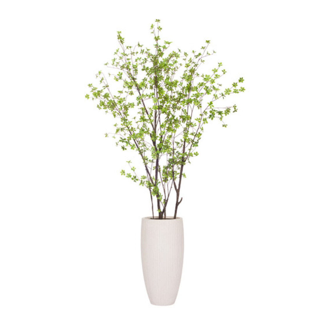 Artificial leafy green plant in tall white textured vase, botanical decor.