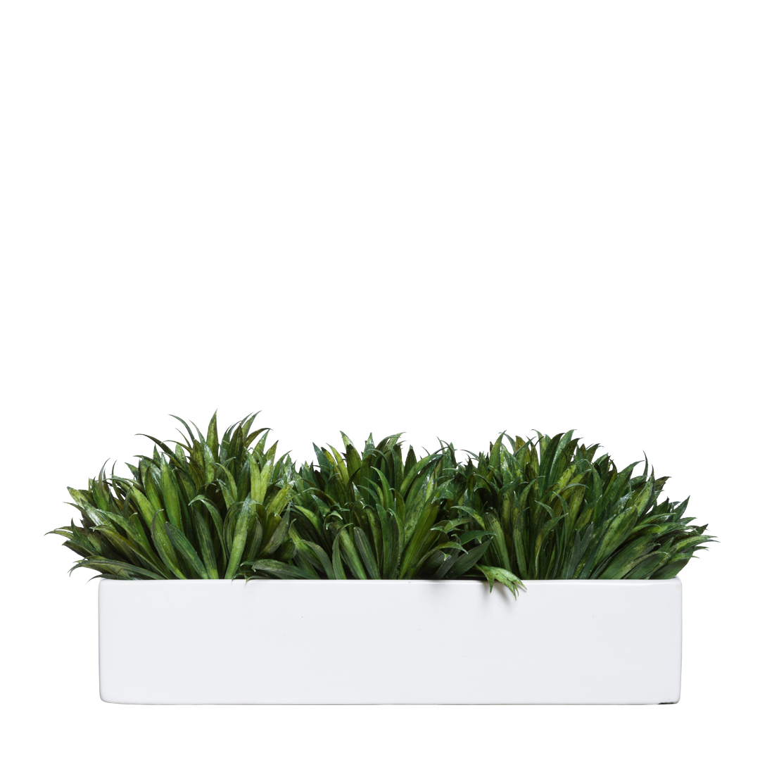 Lush artificial green grass arrangement in a modern rectangular white planter