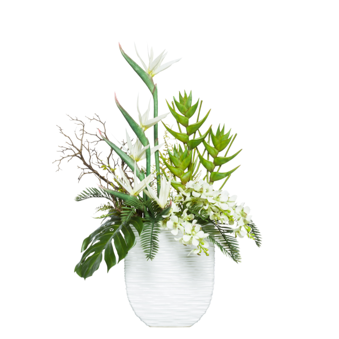 Artificial tropical floral arrangement with white flowers and greenery in a textured white vase