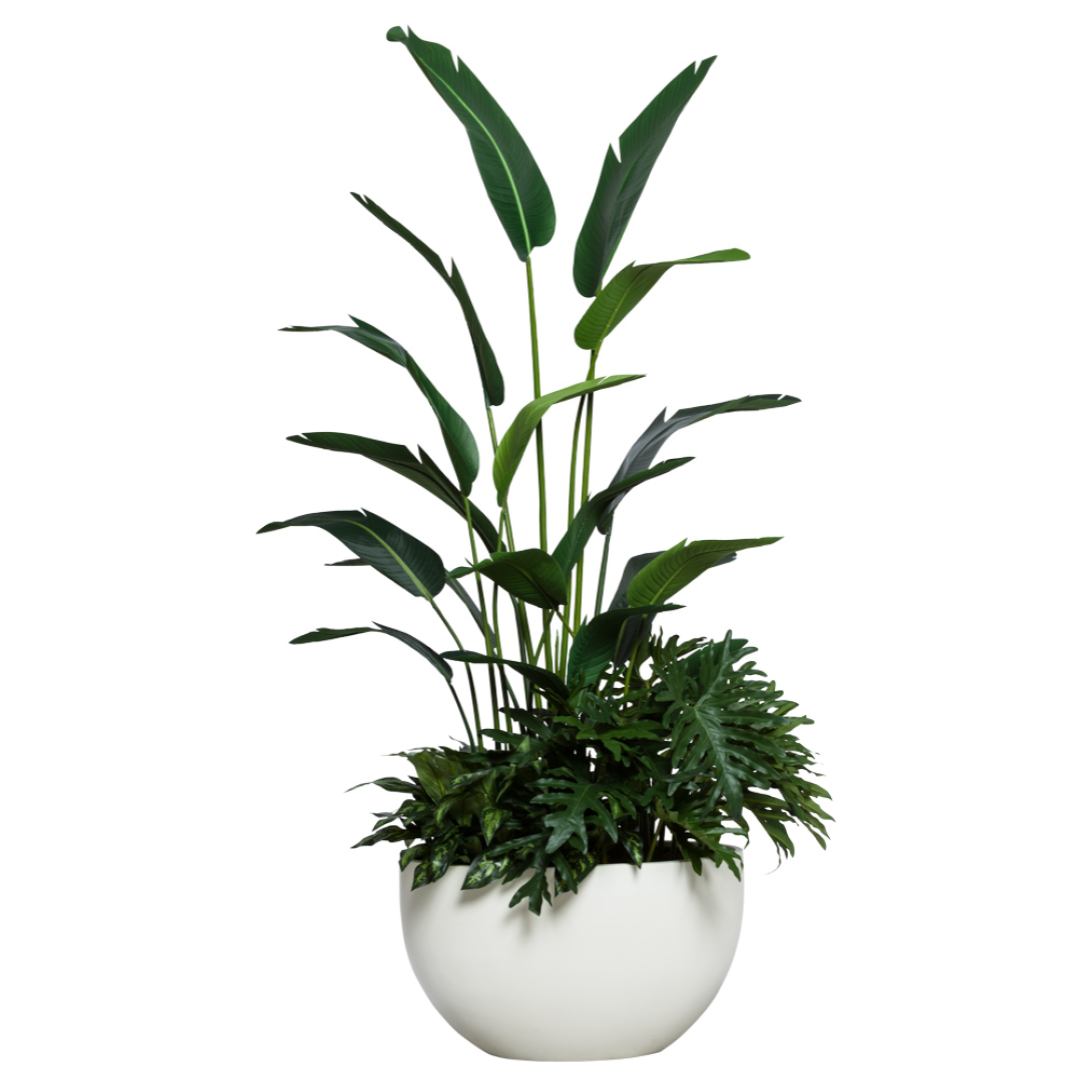 Artificial tropical palm and philodendron plant in modern white planter