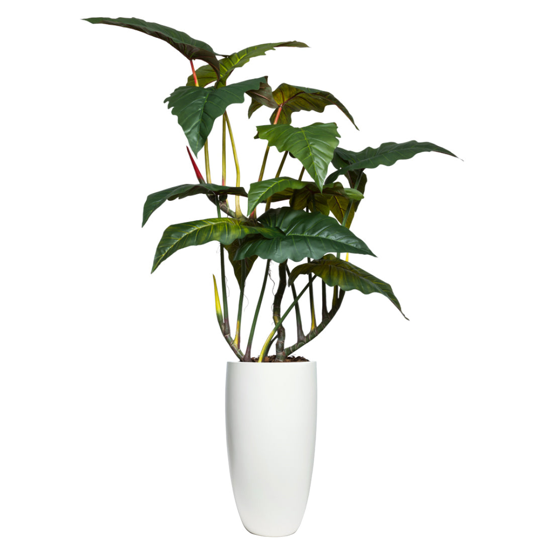 Tall artificial philodendron plant with large green leaves in a modern white planter