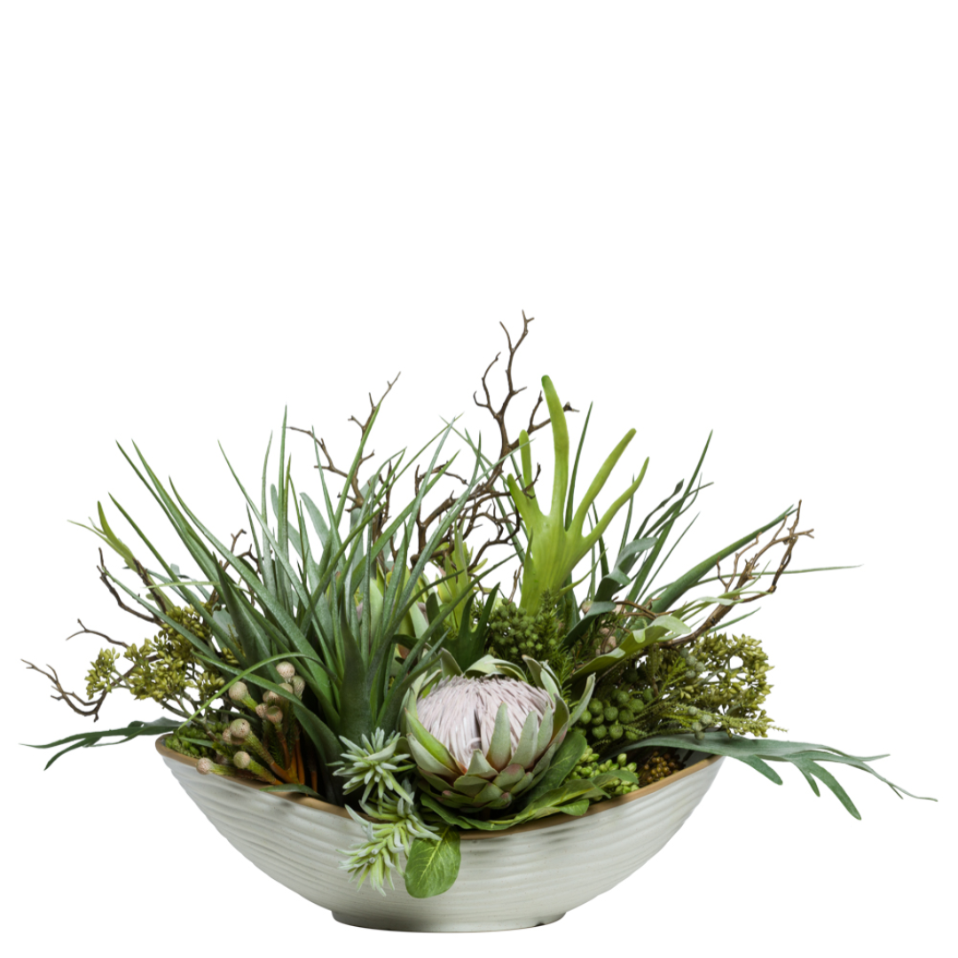 Artificial protea and staghorn succulent arrangement in a white ceramic bowl