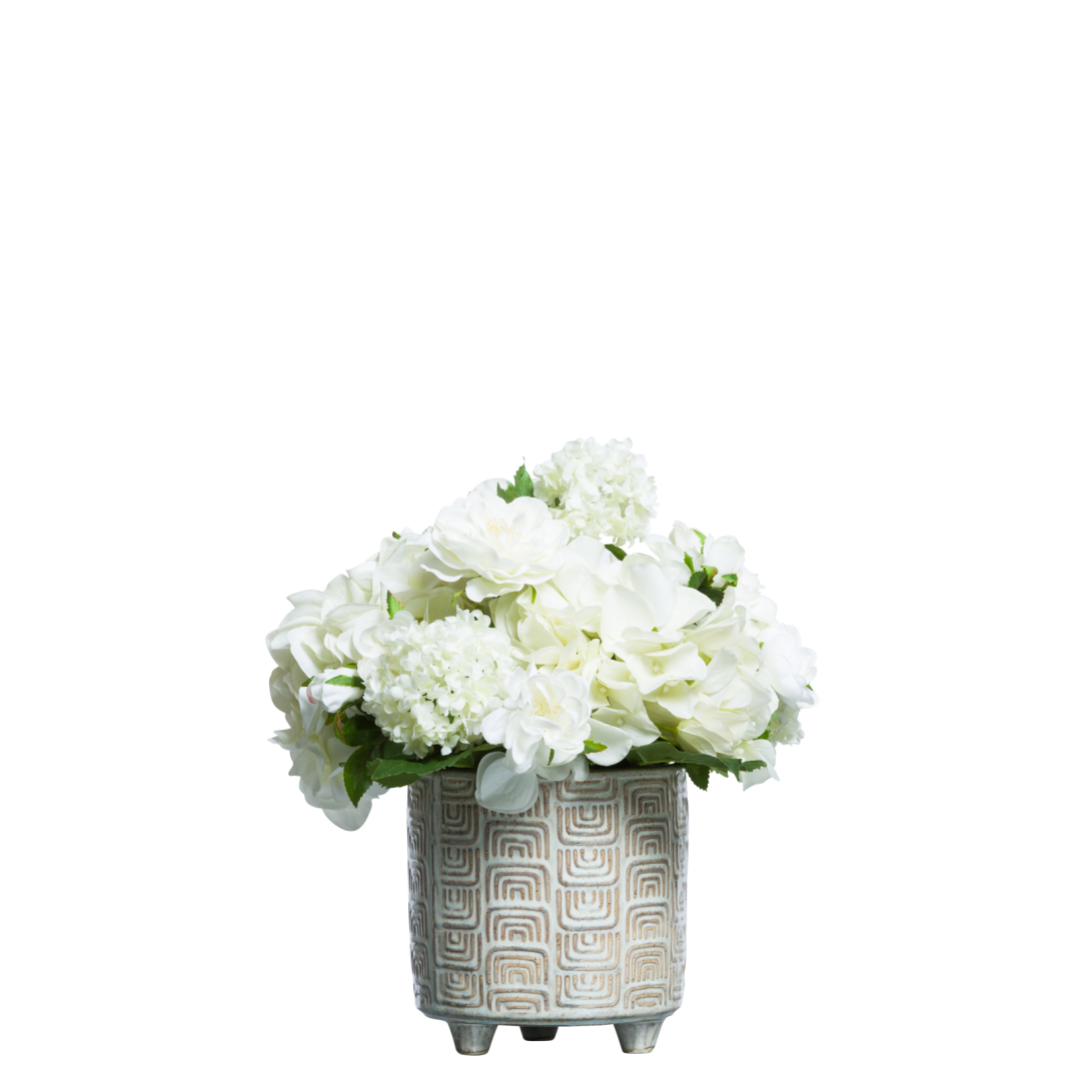 White artificial roses and hydrangeas arrangement in a patterned ceramic pot
