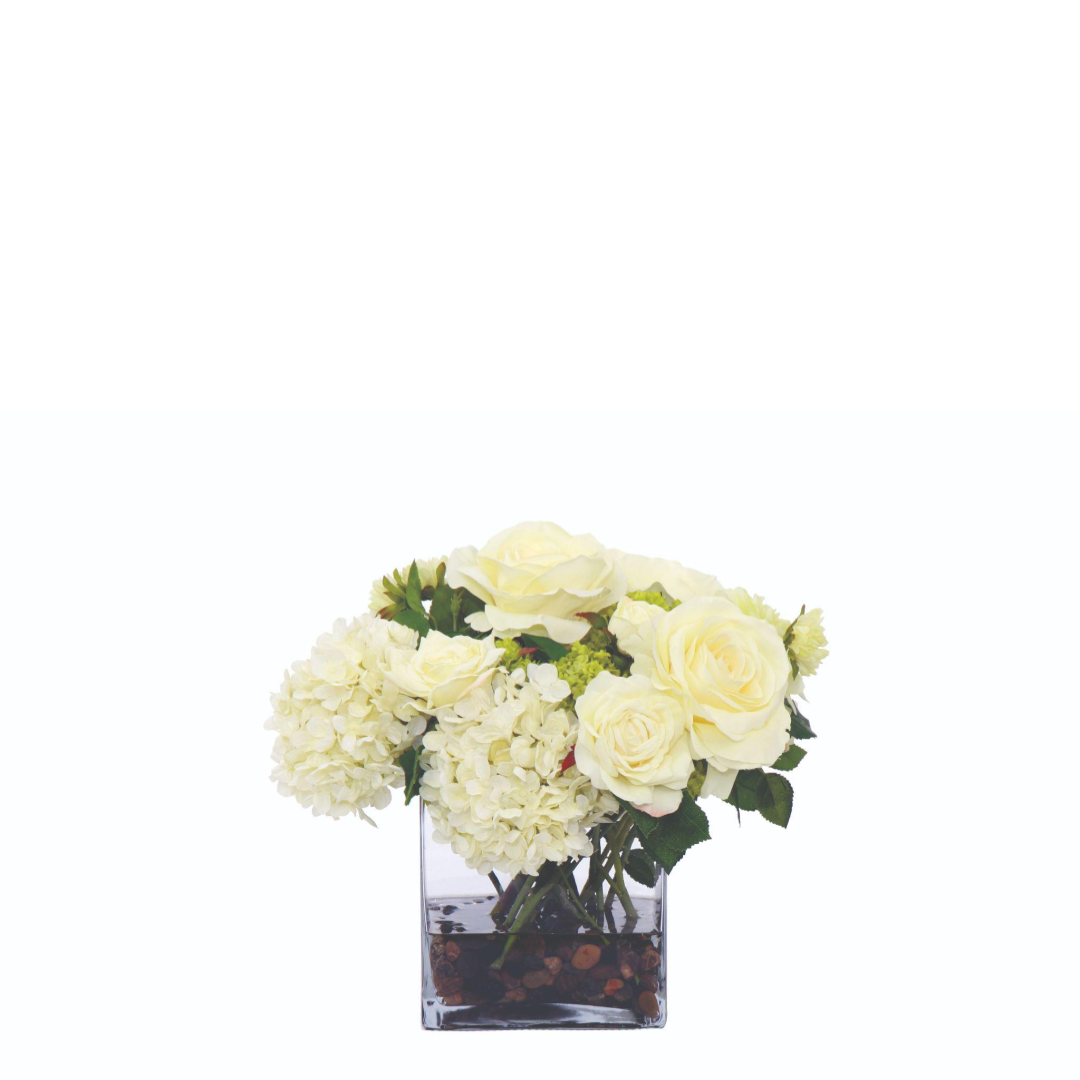 Cream roses and hydrangeas silk flower arrangement in a clear glass vase