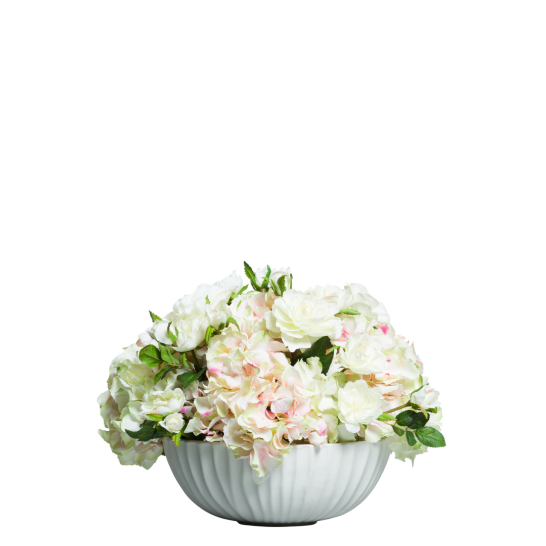 Artificial white roses and hydrangeas in a ceramic bowl centerpiece arrangement
