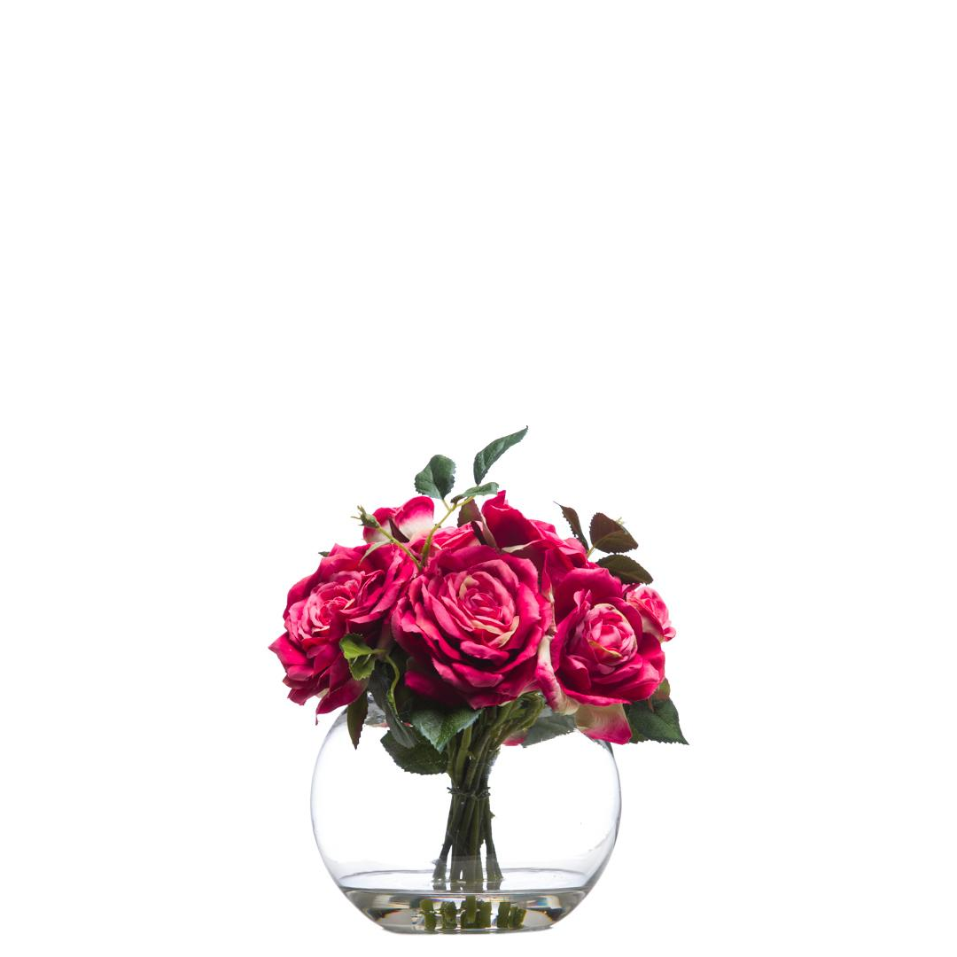 Artificial pink rose bouquet in a round clear glass vase on a white background