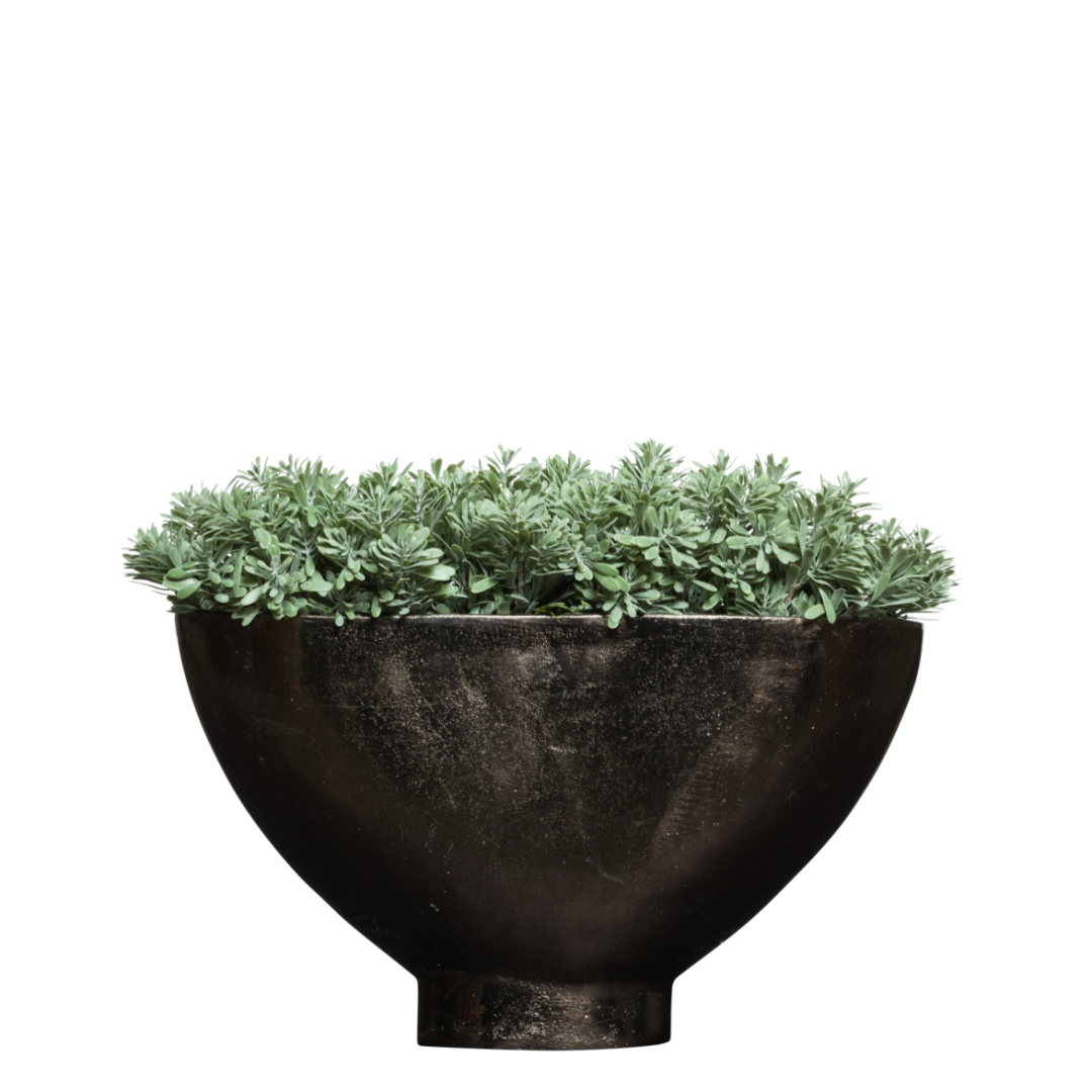 Artificial succulent arrangement in a black modern bowl planter on white background