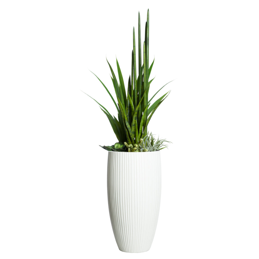 Artificial succulents and greenery arrangement in a tall white ribbed planter