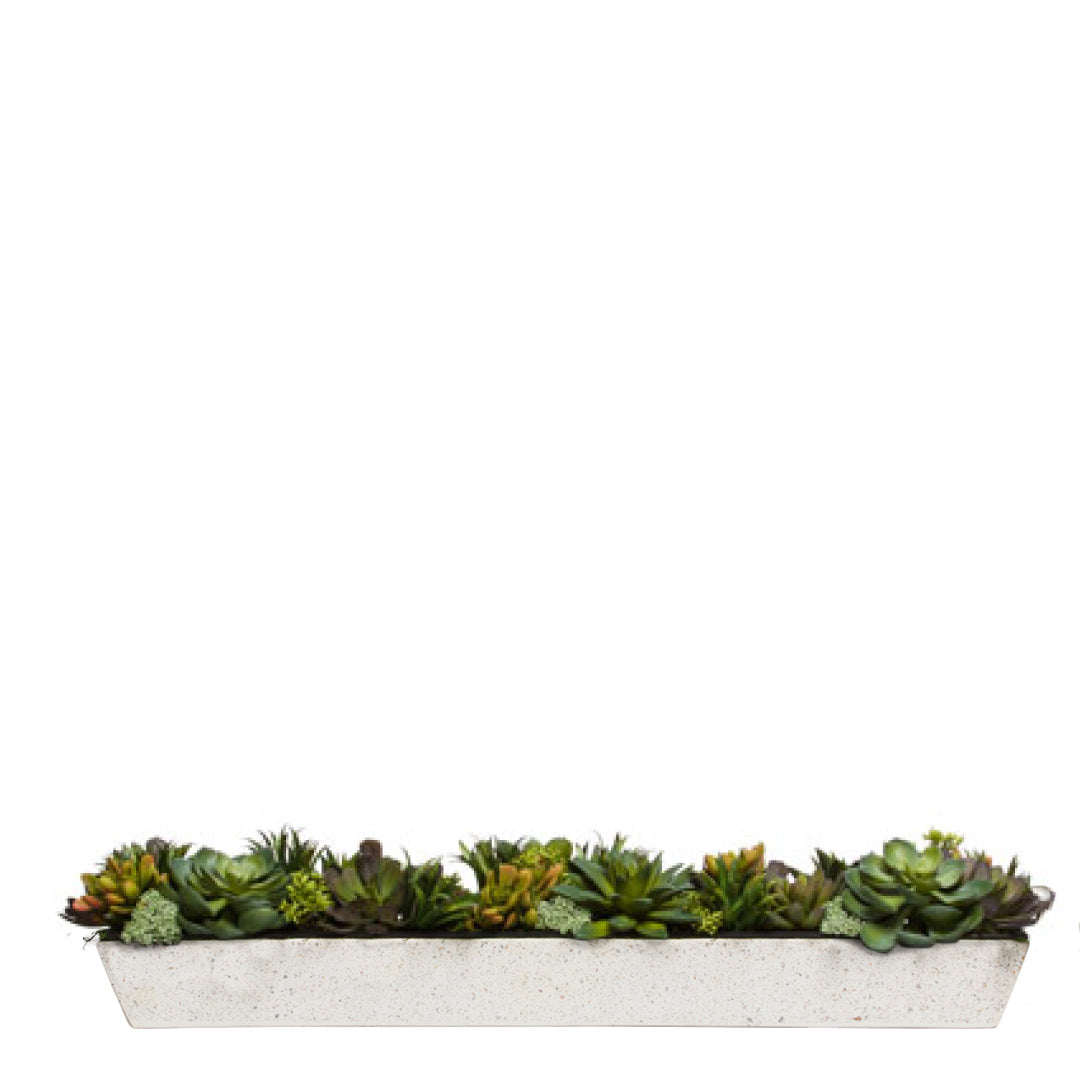 Artificial succulent arrangement in a long white rectangular planter on a white background
