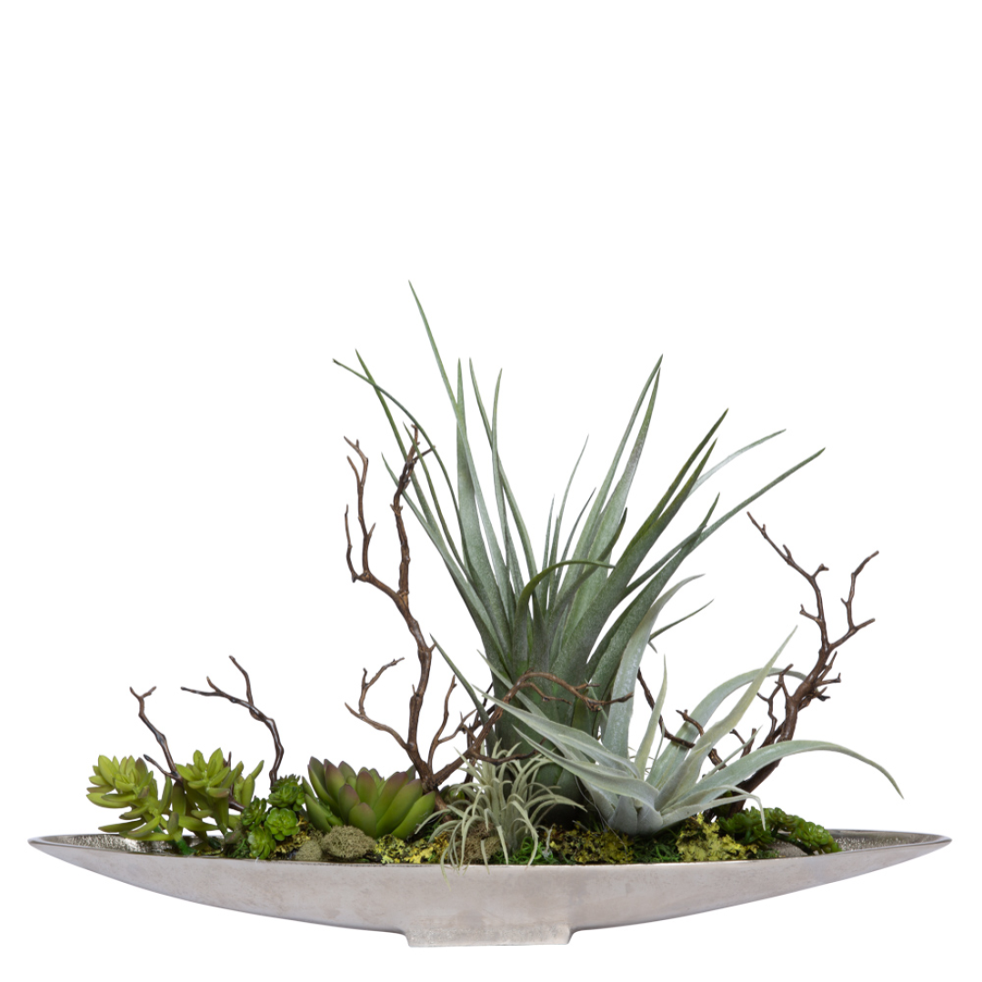 Artificial mixed succulents and air plants in an elongated silver planter with branches