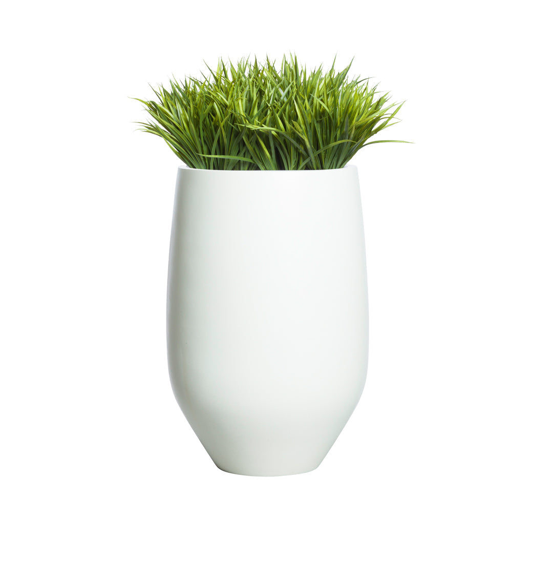 Artificial sword grass in a modern white ceramic vase on white background