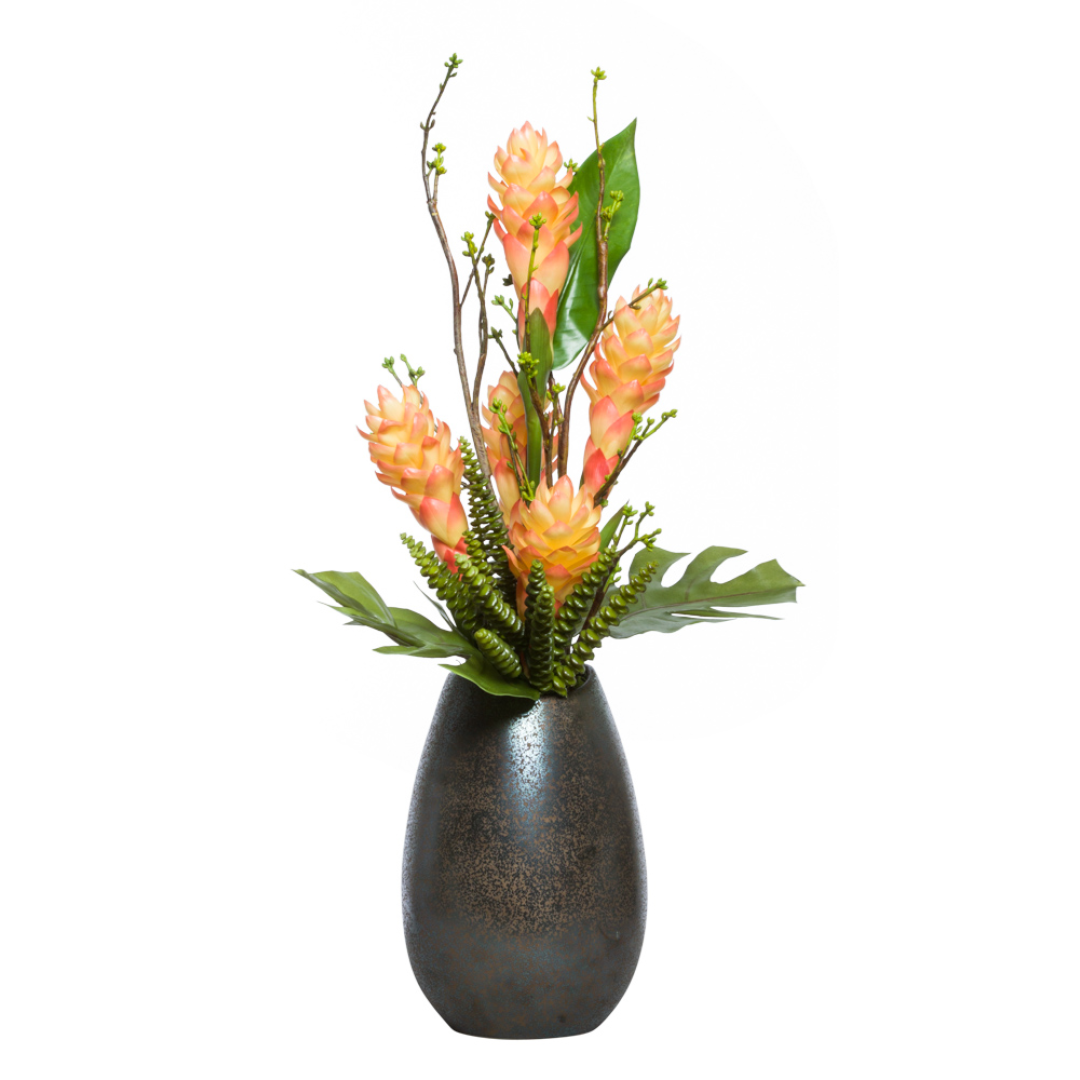 Artificial torch ginger flower arrangement in textured black vase with tropical greenery