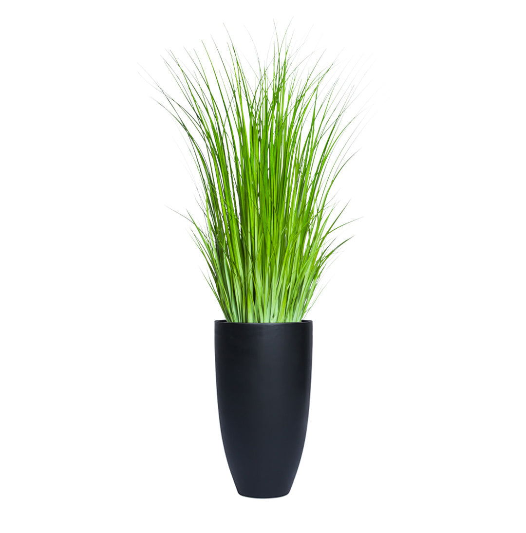 Tall artificial wild grass in a smooth black planter on white background