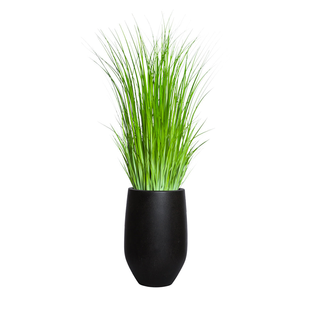 Artificial wild grass in a modern black planter on a white background