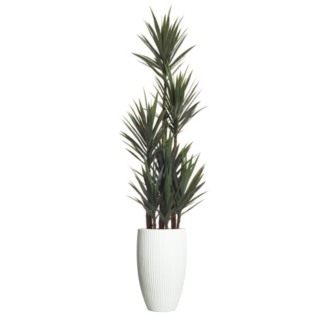 Artificial yucca plant in tall white ribbed planter against a white background