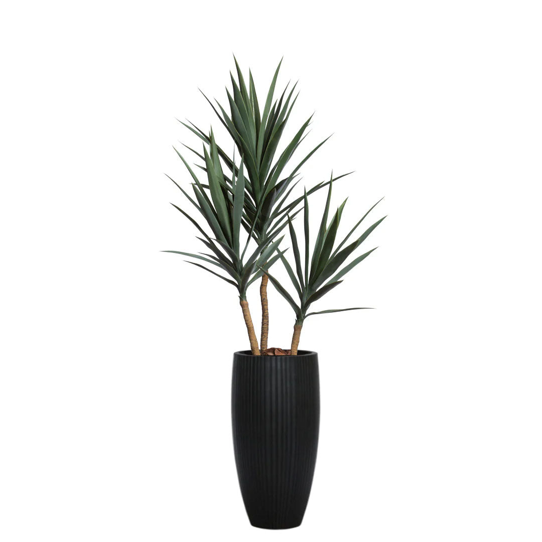 Artificial yucca plant with green leaves in a tall black ribbed planter
