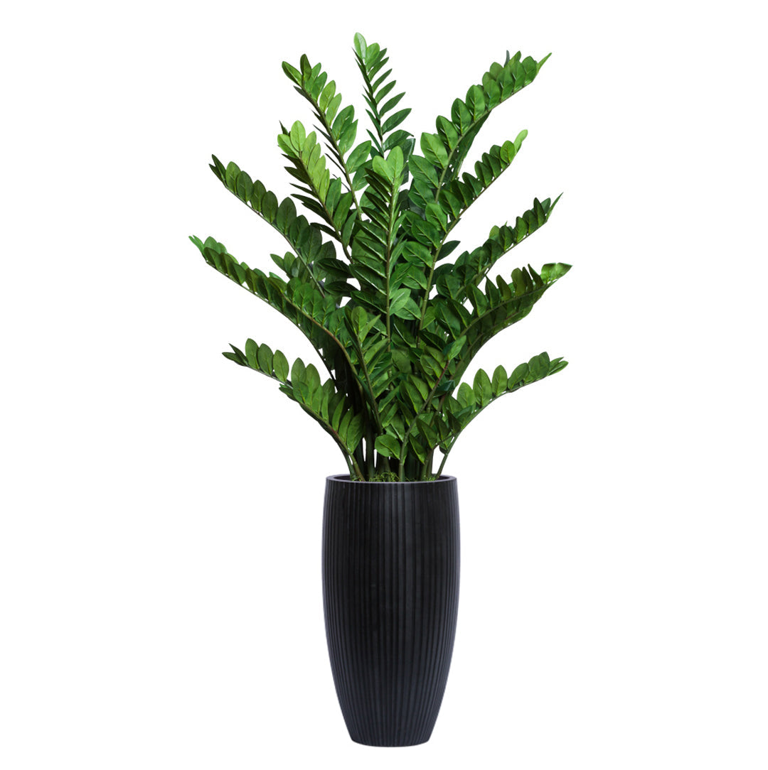 Artificial zamiifolia plant with glossy green leaves in a tall black ribbed planter