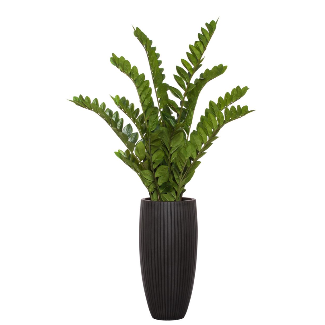 Artificial zamiifolia plant with lush green leaves in a tall, ribbed black planter