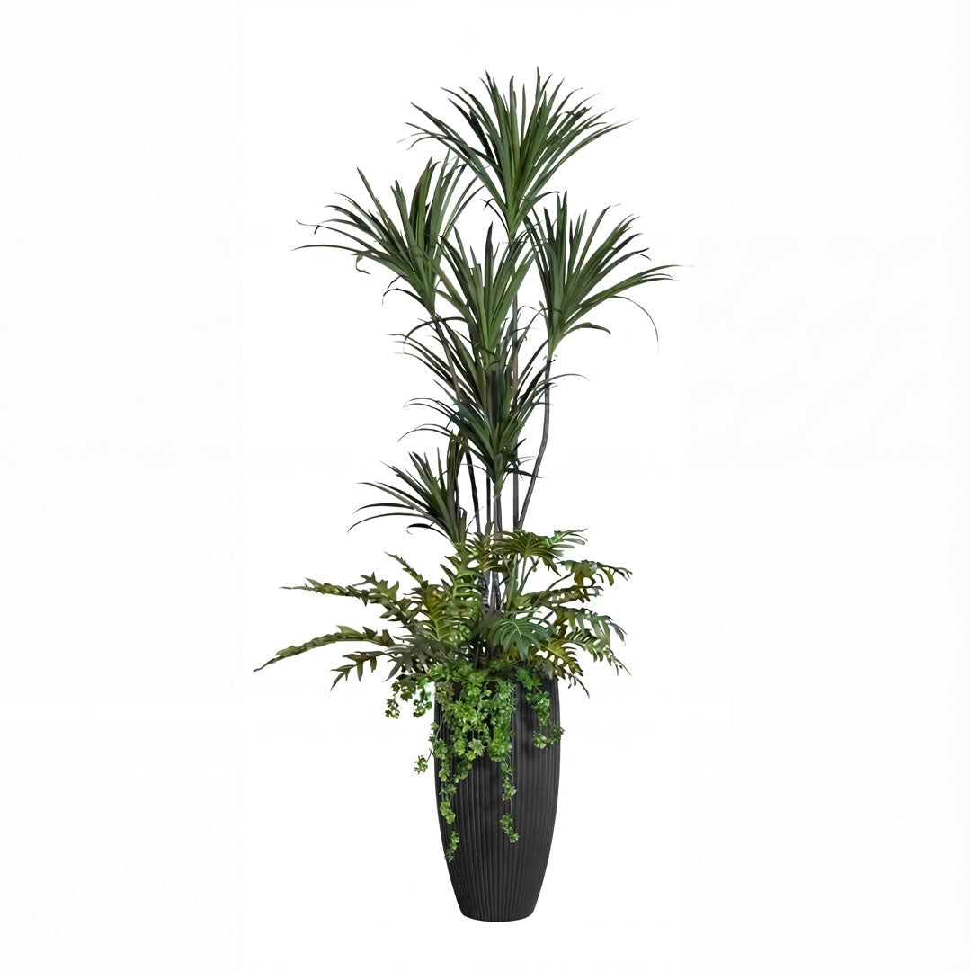 Artificial tropical plant arrangement in a tall black ribbed planter on white background