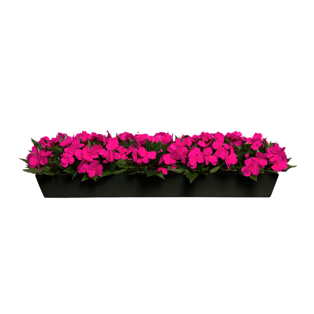 Artificial fuchsia flowers in a rectangular black planter, lush green leaves, floral decor