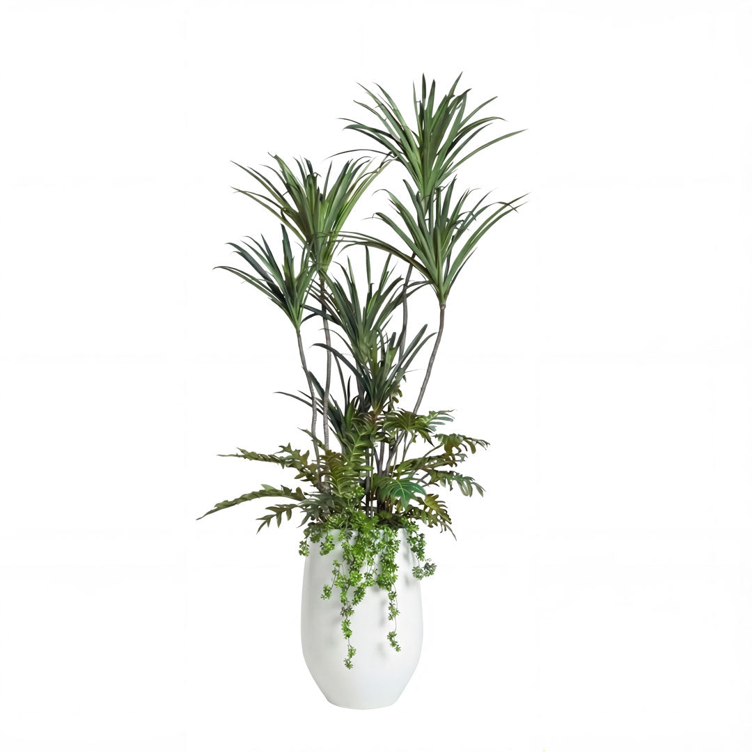 Artificial tropical plant arrangement in a modern white vase with lush green foliage