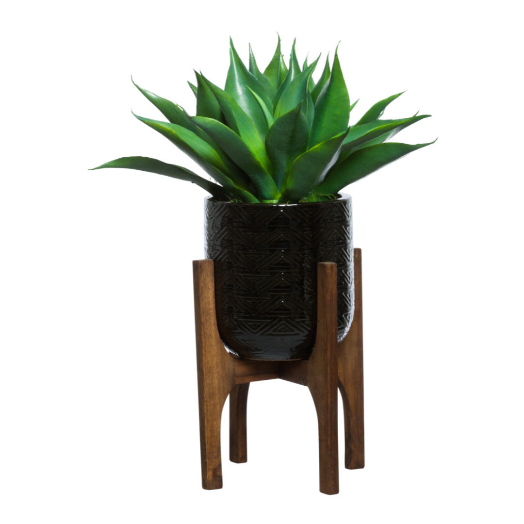 Artificial agave plant in a textured black pot on a wooden stand, modern home decor