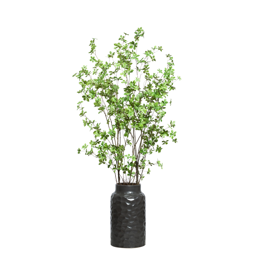Artificial green leafy branches in a textured black vase, modern home decor accent