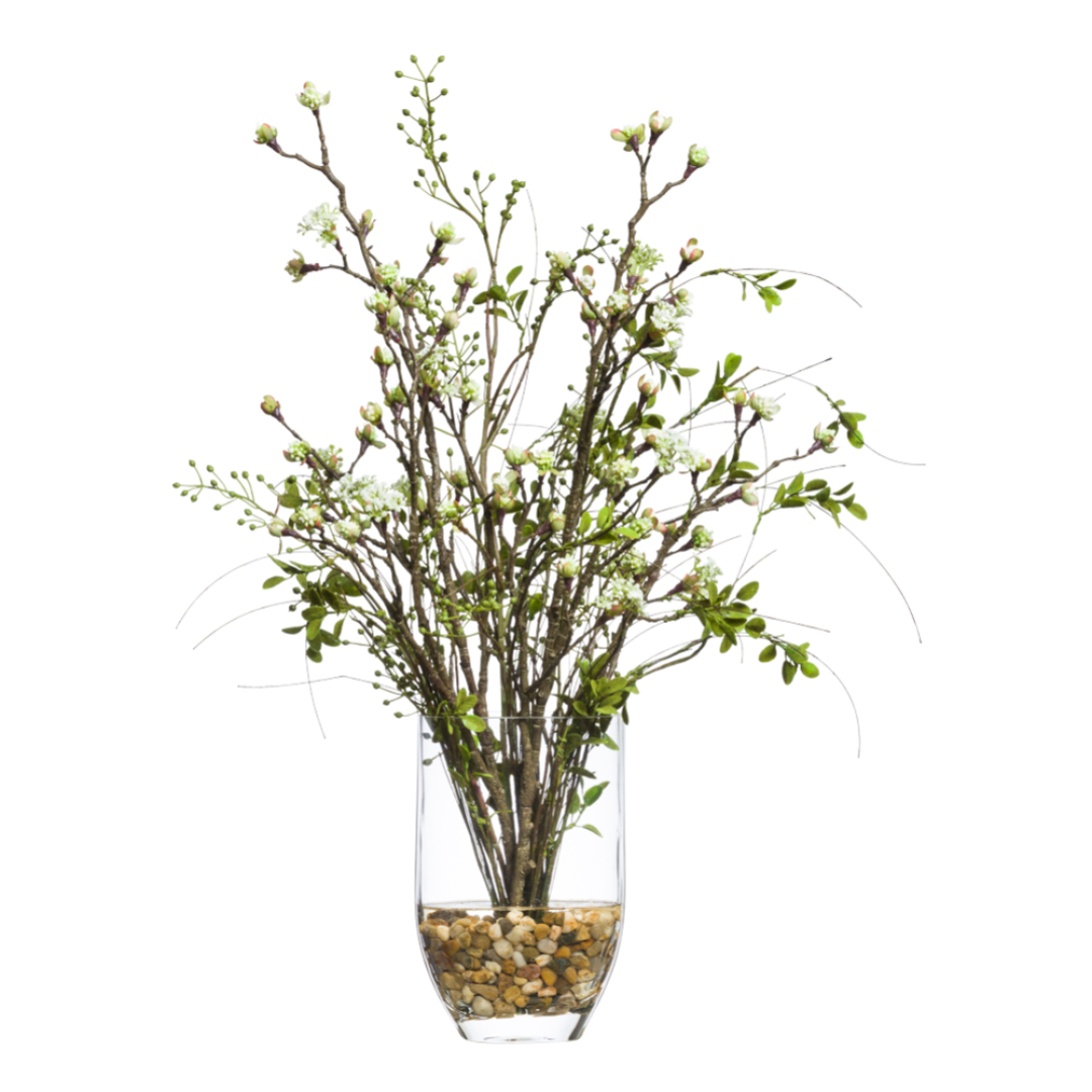 Artificial blossom berry branches in clear vase with pebbles, lifelike floral decor arrangement