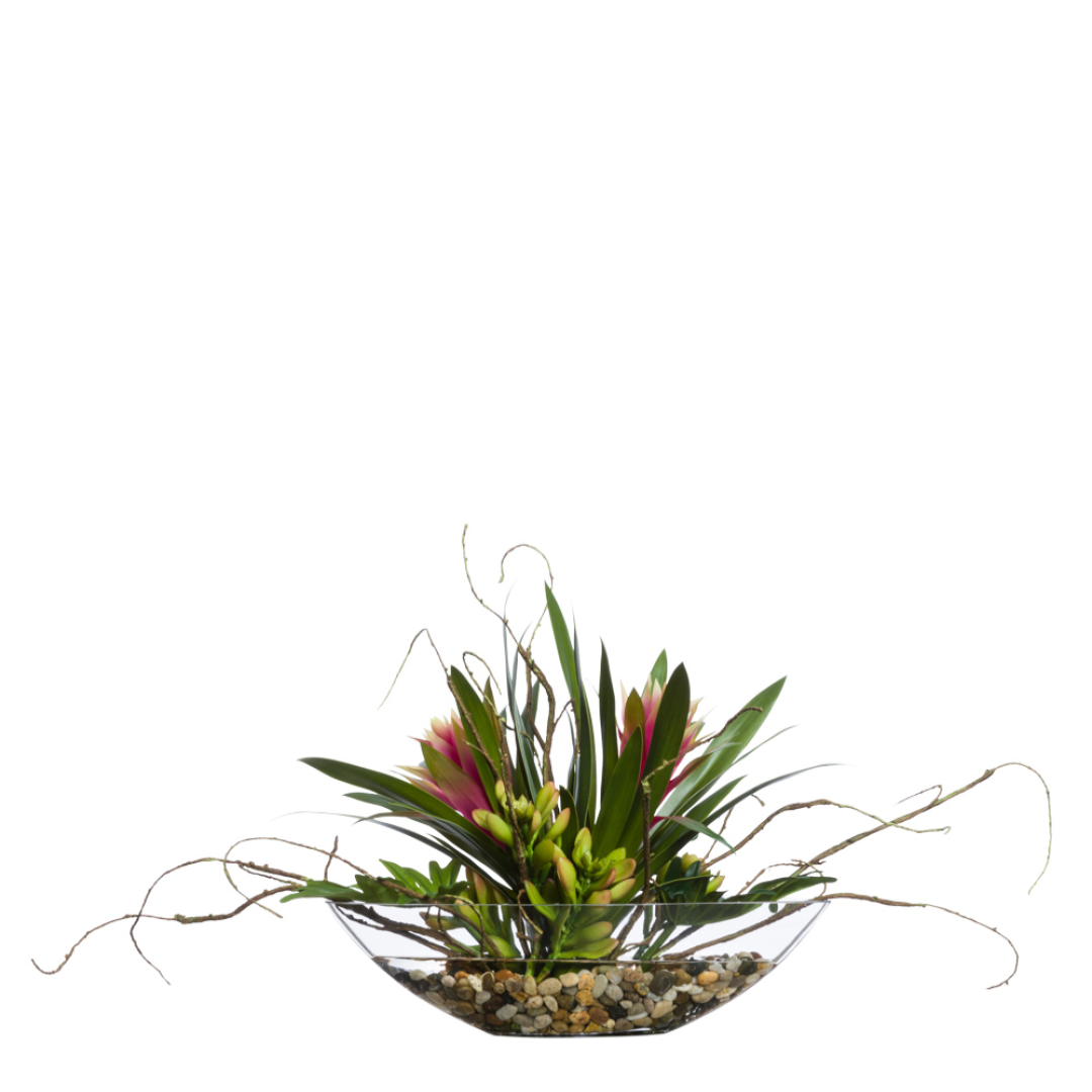 Artificial bromeliad and split leaf arrangement in a glass bowl with pebbles
