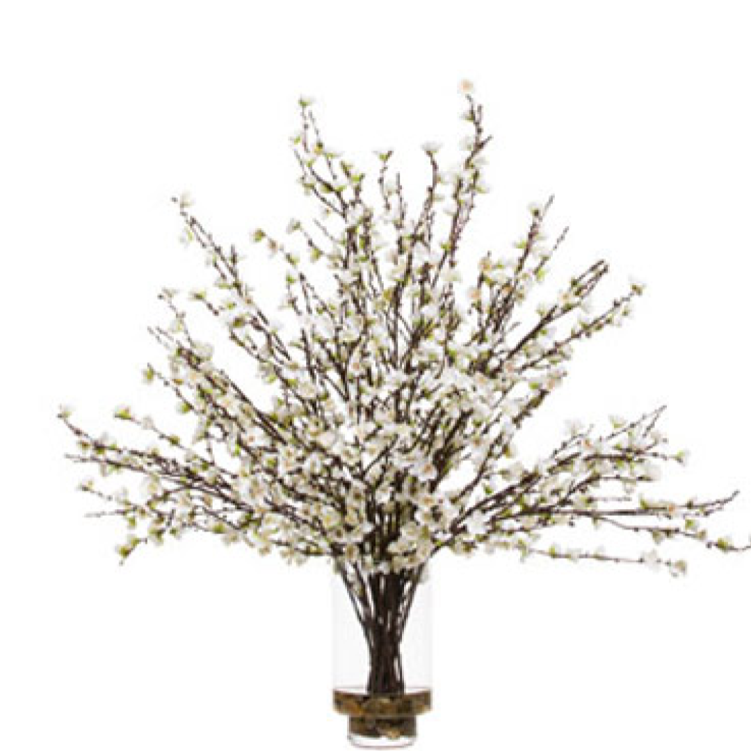 Artificial plum blossom branches with white flowers arranged in a clear glass vase