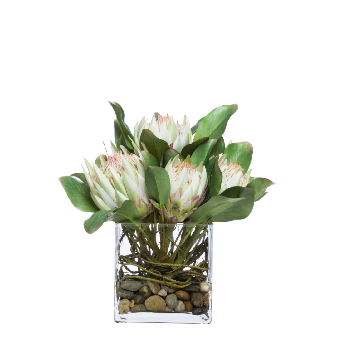 White protea artificial flower arrangement in clear glass vase with rocks