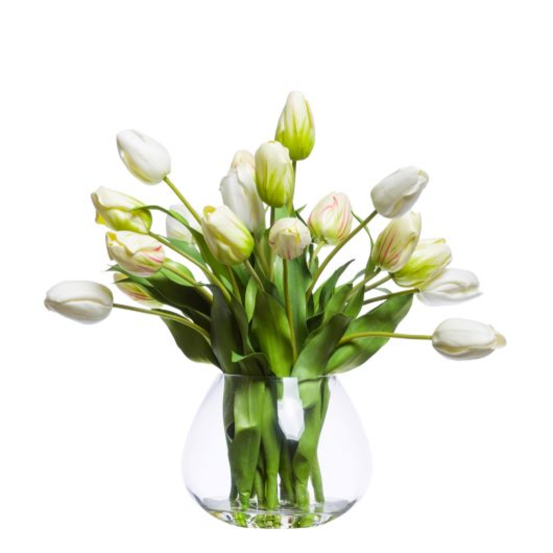 Artificial white tulip arrangement in a clear glass vase with green leaves