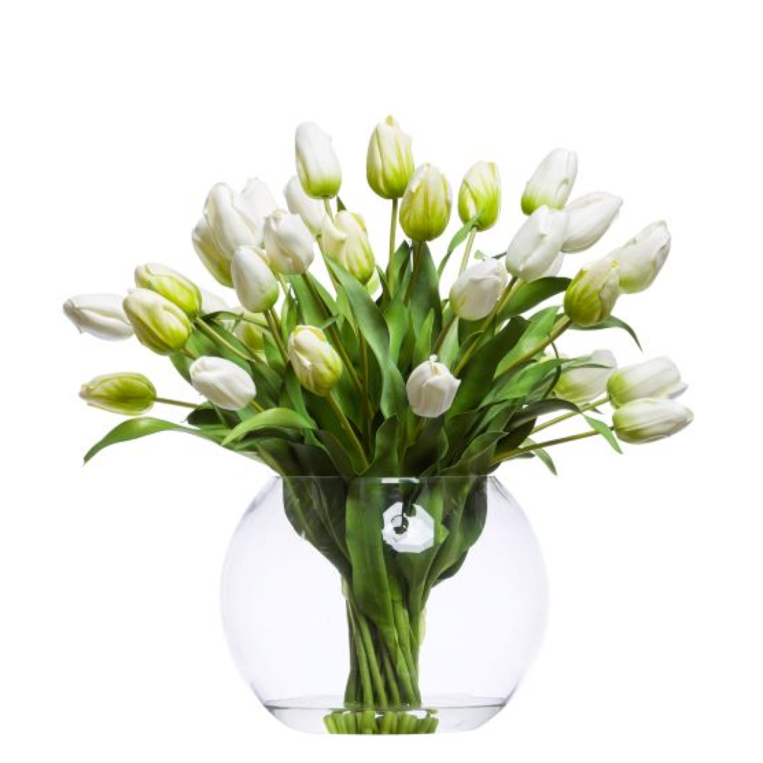 White artificial tulip arrangement in a clear round glass vase with green leaves